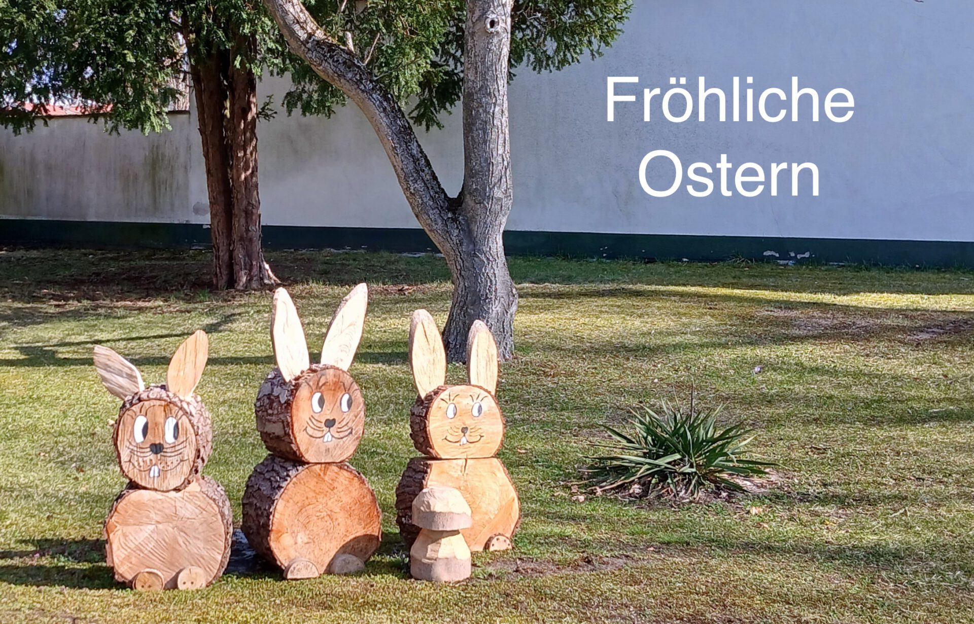 Drei Osterhasen aus Holz auf einer Wiese
