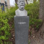 Bronzebüste von Friedrich Simon Archenhold (1861–1939) auf Sockel mit Inschrift in parkähnlicher Umgebung der Archenhold-Sternwarte Berlin.