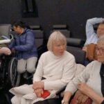 Menschen mit Lock-in-Syndrom und Unterstützer bei einem Treffen in der Archenhold Sternwarte Berlin. Kommunikation über spezielle Hilfsmittel.