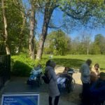 Menschen mit Locked-in-Syndrom und Unterstützer tauschen sich im Zenner Biergarten aus. Sie nutzen Kommunikationshilfen und genießen die Gemeinschaft.