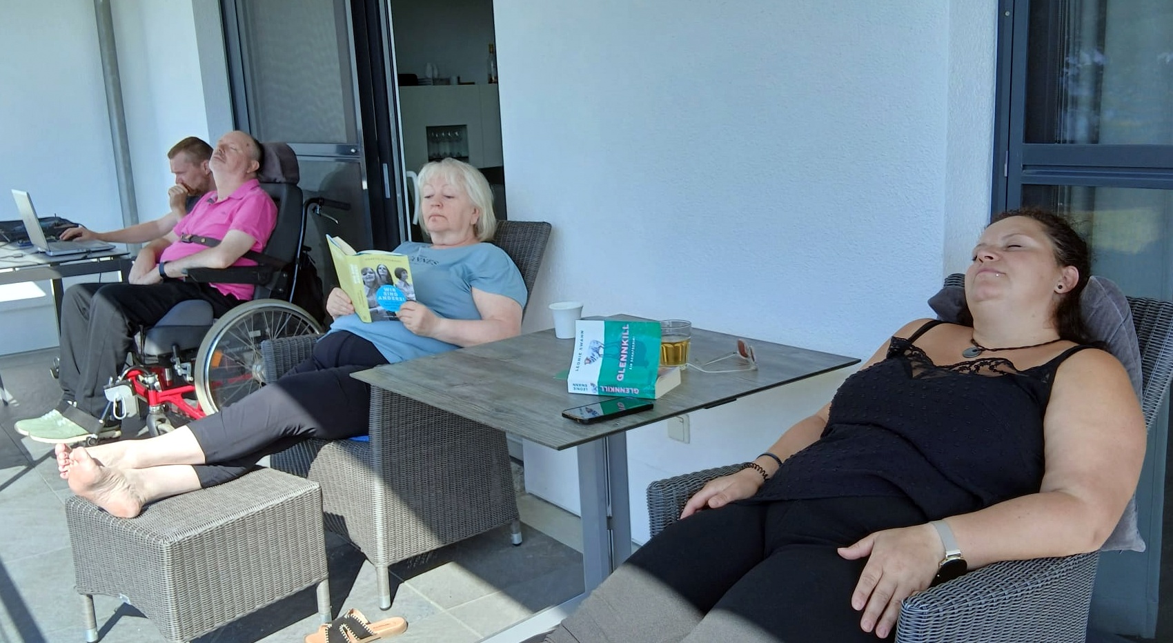 Vier Personen entspannen auf einem Balkon