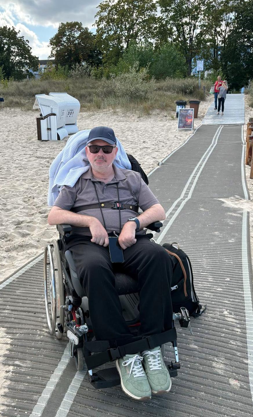 Mann im Rollstuhl auf dem Weg zum Strand